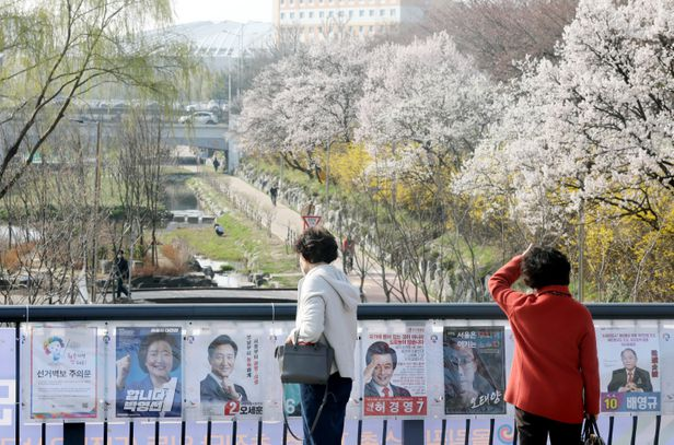 4.7 서울시장 재·보궐선거 공식 선거운동 첫날인 3월 25일 서울 송파구 오륜동에서 시민들이 서울시장 후보들의선거벽보를 보고있다. /뉴시스