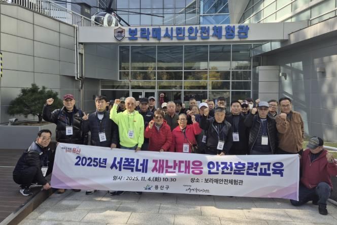 용산구가 추진한 재난대응 안전훈련에 참가한 서울역 쪽방주민들이 교육을 마치고 단체 기념촬영을 하고 있다