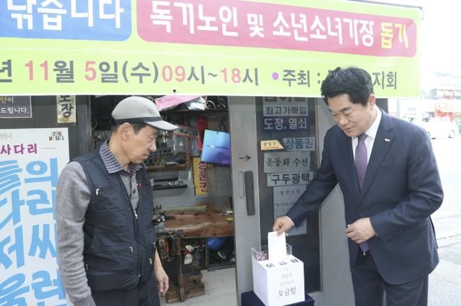 관악구 사랑의 구두닦이 행사에서 모금함에 기부하는 박준희 관악구청장