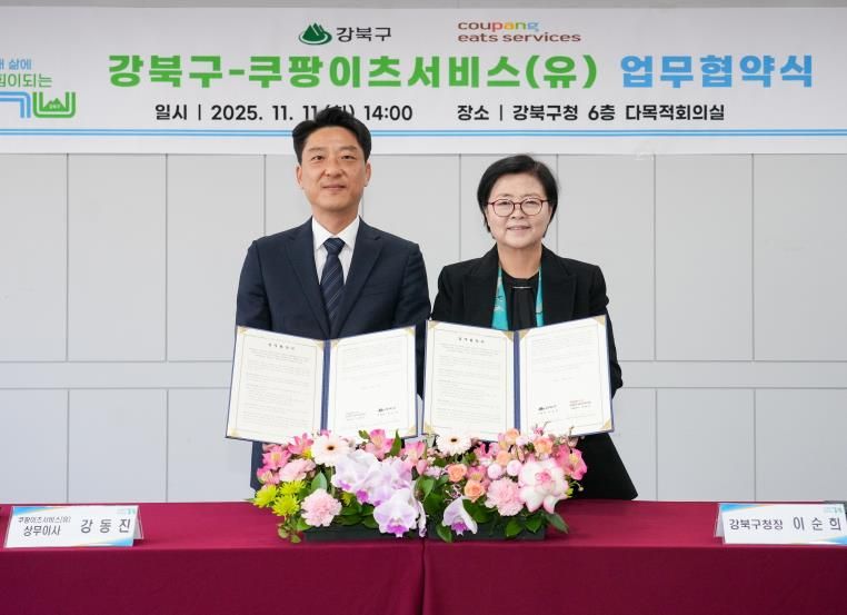 이순희 강북구청장(오른쪽)과 강동진 쿠팡이츠서비스 상무이사가 11일 강북구청 다목적회의실에서 업무협약을 체결한 뒤 협약서를 들어 보이고 있다.