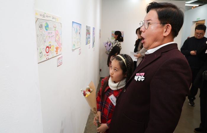 박강수 마포구청장이 수상 어린이와 함께 전시된 그림을 살펴보고 있다.