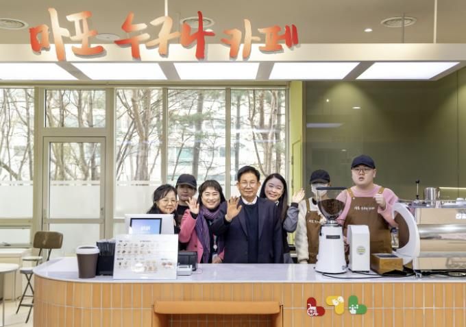 박강수 마포구청장이 ‘마포 누구나 카페’ 2호점 개소식에 참석해 장애인 공동대표 및 관계자들과 함께 기념촬영을 하고 있다.